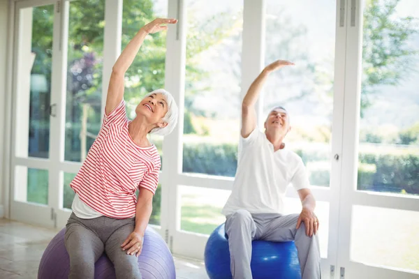 Idősebb pár teljesítő nyújtó gyakorolni fitness labda — Stock Fotó