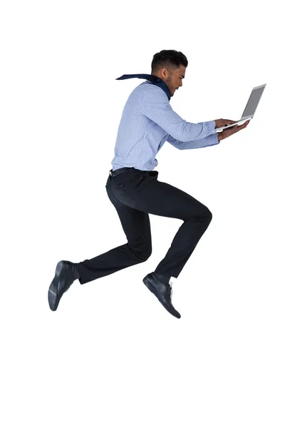 Empresário pulando ao usar laptop — Fotografia de Stock