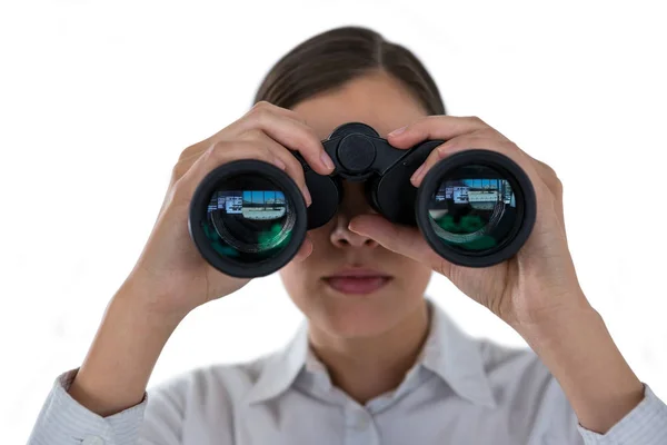Empresária olhando através de binóculos contra um fundo branco — Fotografia de Stock