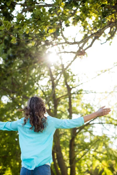 Donna in piedi con le braccia tese nel parco — Foto Stock