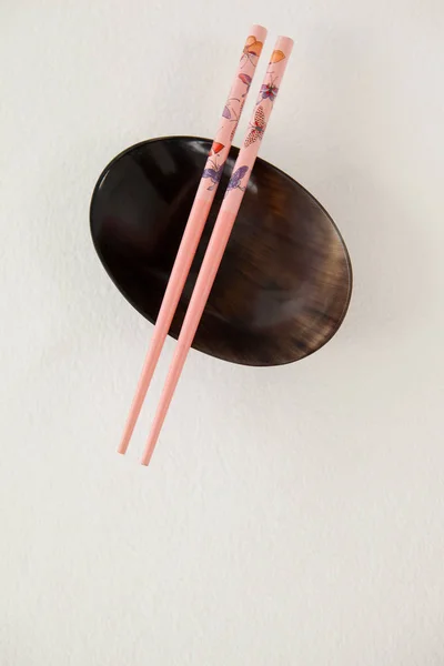Pair of chopsticks over a bowl — Stock Photo, Image