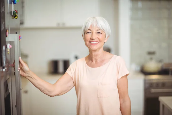 Porträtt av senior kvinna som står i köket — Stockfoto