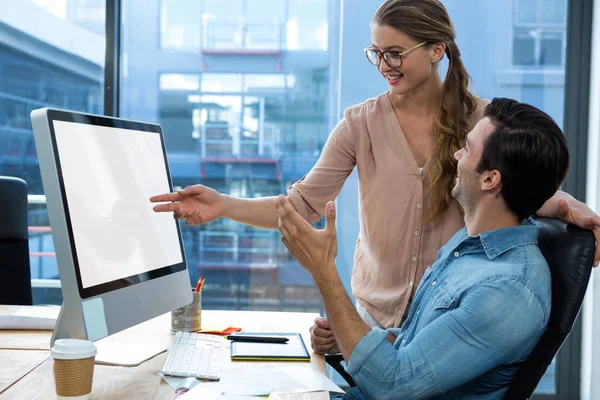 Graphic designer working at desk with colleague — Stock Photo, Image