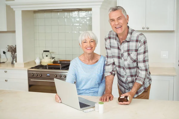 Äldre par hålla medicin flaska och använder bärbar dator — Stockfoto