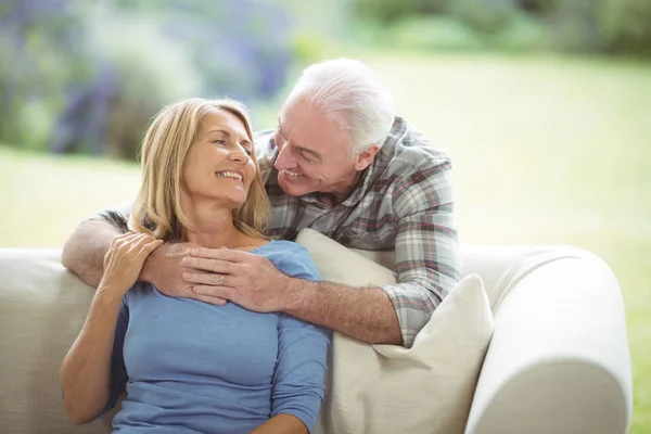 Starší muž objímá žena v obývacím pokoji — Stock fotografie