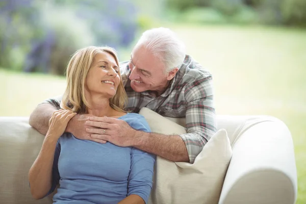 Senior man omarmen een vrouw in woonkamer — Stockfoto