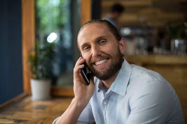 Uomo sorridente che parla sul cellulare al caffè — Foto Stock