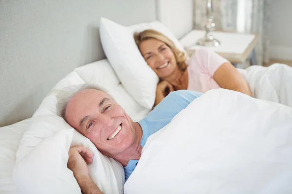 Felice coppia anziana sdraiata sul letto — Foto Stock