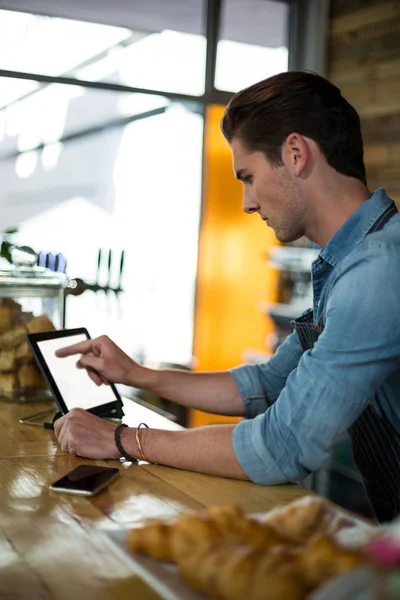 Cameriere in piedi al bancone con tablet digitale — Foto Stock