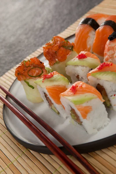 Σύνολο ανάμικτες σούσι σερβίρεται με chopsticks για σούσι ματ μαύρο φόντο — Φωτογραφία Αρχείου