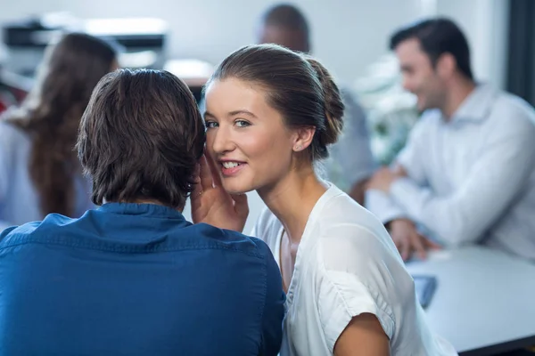 Vrouwelijke ondernemer fluisteren aan haar collega — Stockfoto