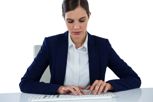 Деловая женщина, печатающая на клавиатуре за столом — стоковое фото