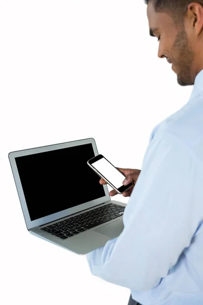 Homem de negócios usando telefone celular e laptop — Fotografia de Stock