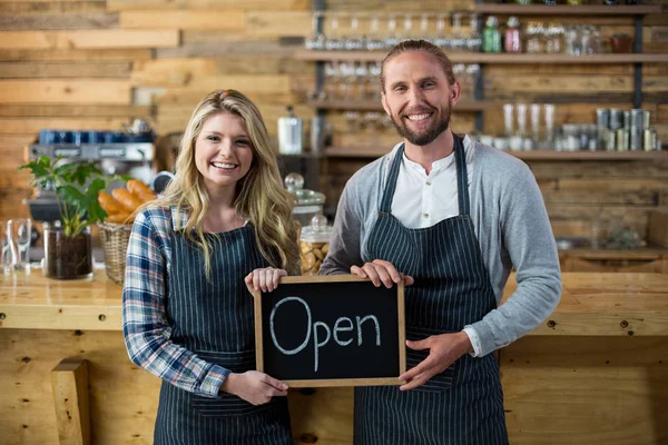 Ler servitris och servitör som står med öppna tecken styrelsen i café — Stockfoto