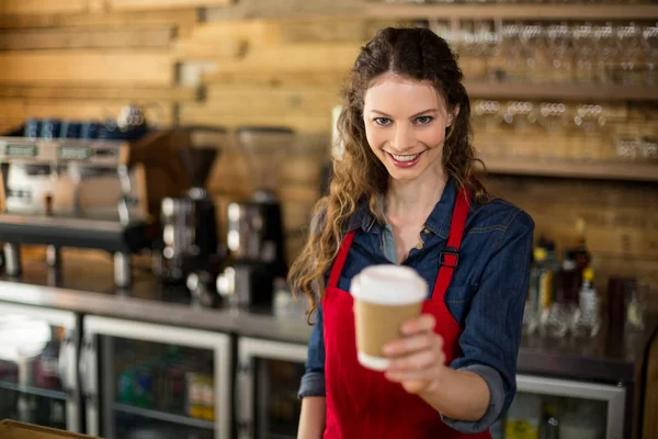 Glimlachend serveerster serveren een kopje koffie aan klant in café — Stockfoto