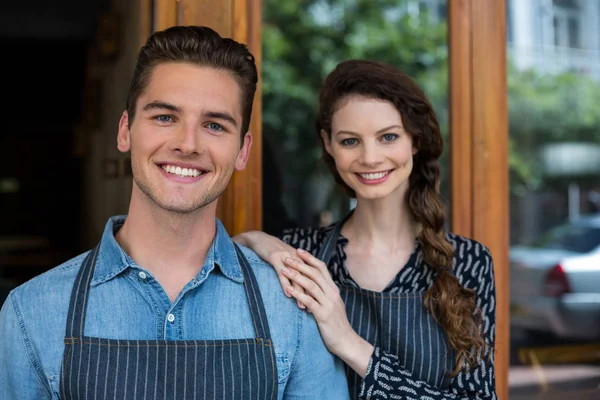 Smiling waiter and waitress standing outside the cafe — Stock Photo, Image