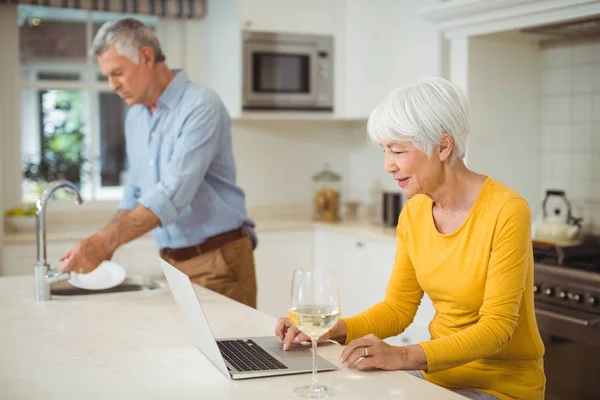 Seniorin benutzt Laptop in Küche — Stockfoto