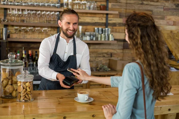 Vrouw betalen via smartphone met nfc technologie — Stockfoto