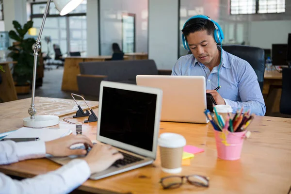 Business executives using laptop at desk — Stock Photo, Image