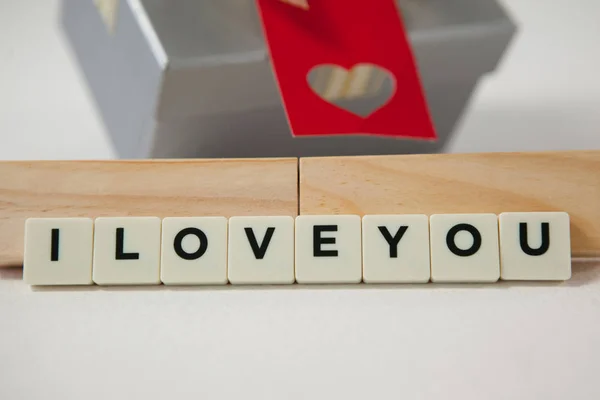 Gift and blocks displaying I love you message — Stock Photo, Image
