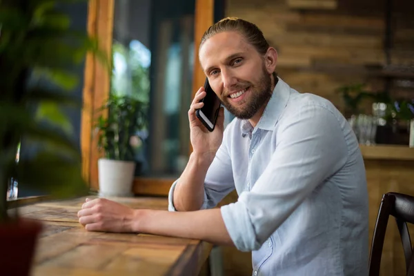 Sonriente hombre hablando por teléfono móvil en la cafetería —  Fotos de Stock