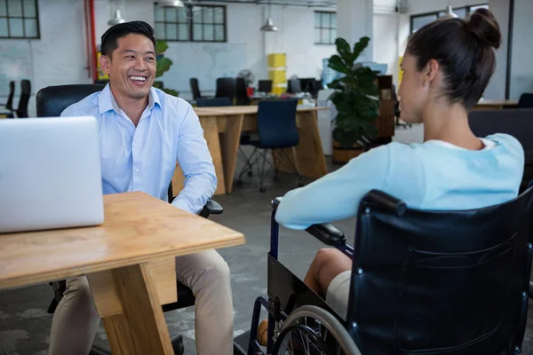 Улыбающийся бизнесмен взаимодействует с коллегой-инвалидом — стоковое фото