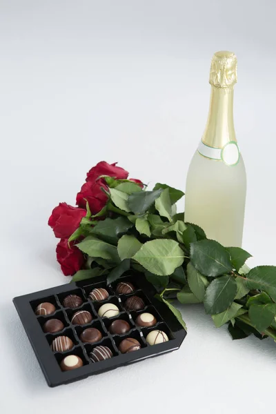 Boîte de chocolat, roses et bouteille de champagne — Photo