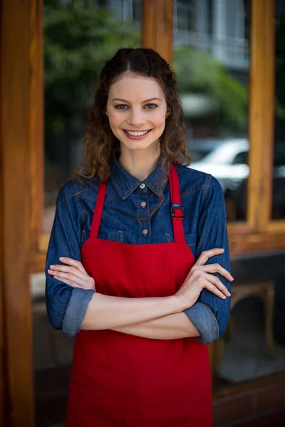 Portret van lachende serveerster permanent met armen gekruist — Stockfoto