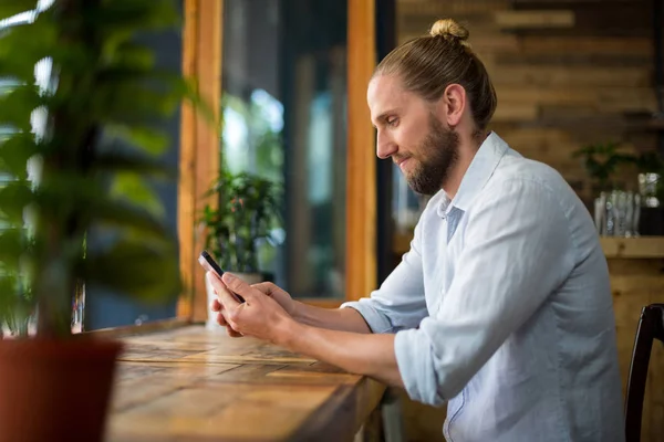 Człowiek przy użyciu telefonu komórkowego w kawiarni — Zdjęcie stockowe