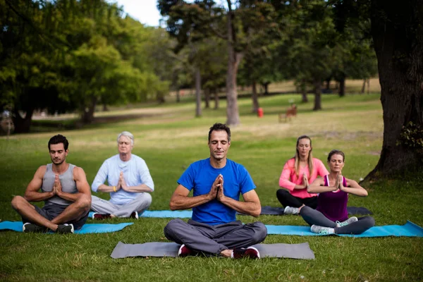 Grupp av människor som utför yoga — Stockfoto