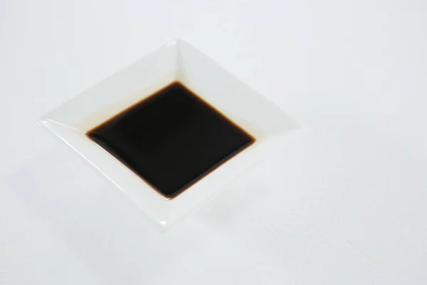 Soy sauce in a square bowl on white background — Stock Photo, Image