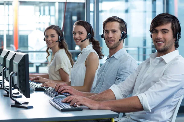 Företagsledare med headset använder dator i office — Stockfoto
