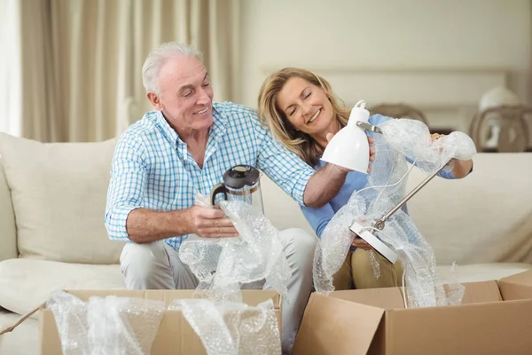 Casal sênior desembalagem caixas de papelão na sala de estar — Fotografia de Stock