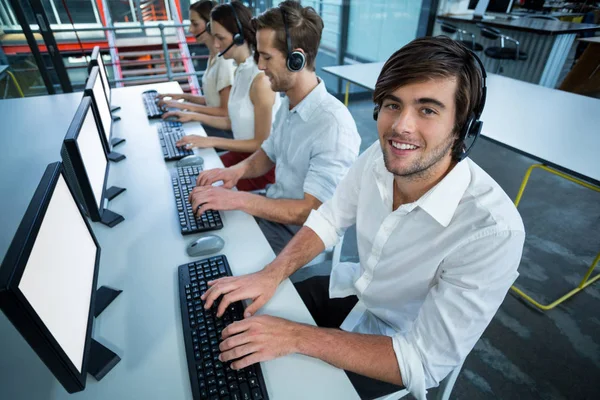 Företagsledare med headset använder dator — Stockfoto