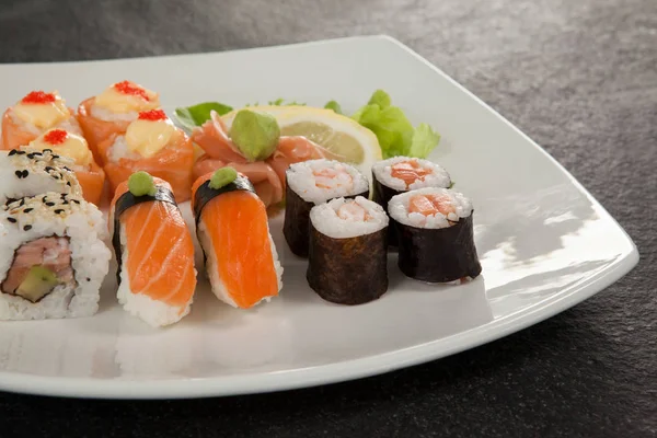 Conjunto de sushi variado servido em uma placa branca — Fotografia de Stock