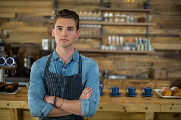 Servitören som står med armarna korsade i café — Stockfoto