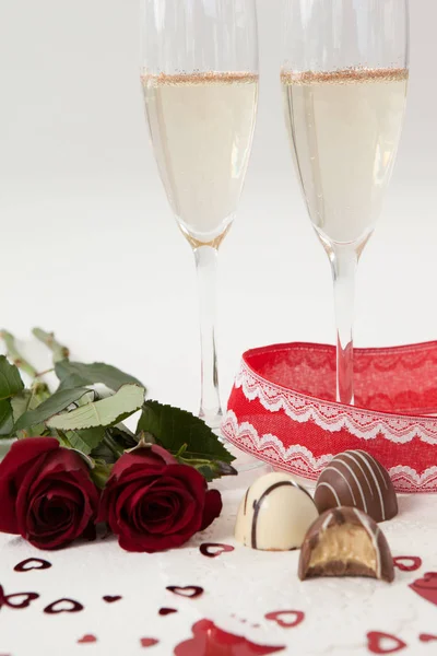 Roses, champagne glass and assorted chocolate — Stock Photo, Image