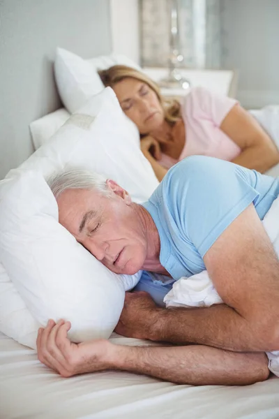 Старшая пара спит на кровати — стоковое фото