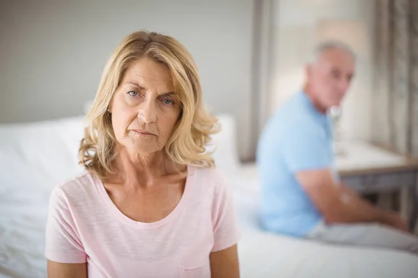 Senior couple ignoring each other on bed in bedroom — Stock Photo, Image