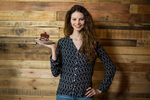 Retrato de mulher sorridente segurando um prato de pastelaria — Fotografia de Stock