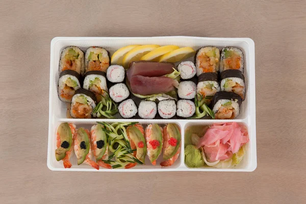 Uppsättning av blandade sushi höll i en vit ruta — Stockfoto