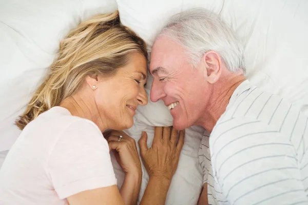 Feliz pareja de ancianos acostados en la cama — Foto de Stock