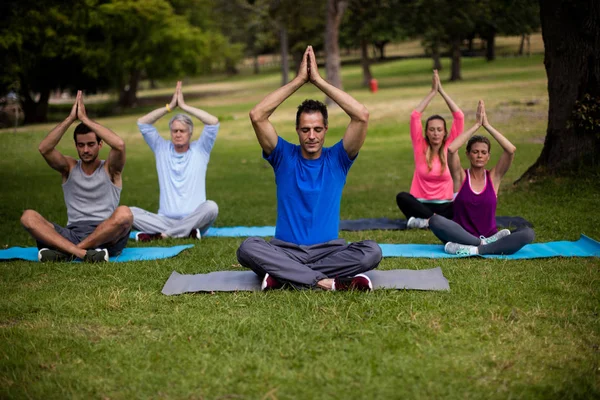 Grupp av människor som utför yoga — Stockfoto