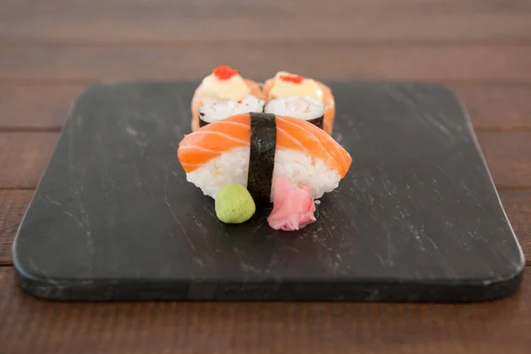 Nigiri och uramaki sushi serveras på svart sten skiffer — Stockfoto