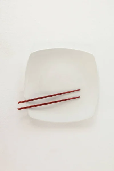 Bir tabakta yemek çubukları çifti — Stok fotoğraf