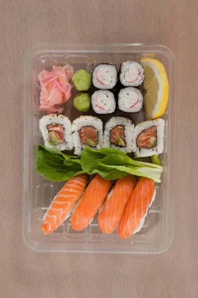 Uppsättning av blandade sushi höll i en plastlåda — Stockfoto