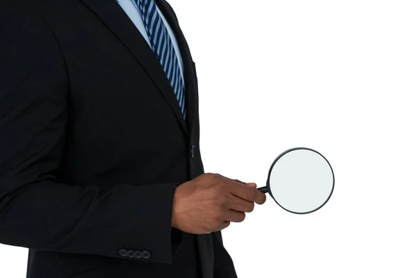 Mid section of businessman holding magnifying glass — Stock Photo, Image
