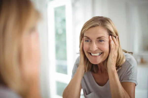 Sorrindo mulher idosa olhando para o espelho — Fotografia de Stock