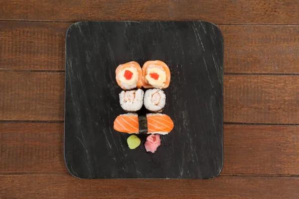 Nigiri a uramaki sushi podávané na černý kámen břidlice — Stock fotografie