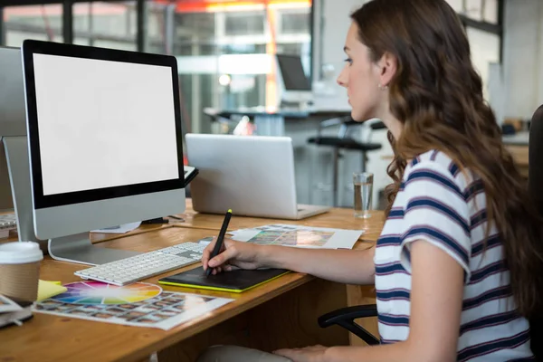 Kobiece projektant graficzny, za pomocą tabletu graficznego o biurko — Zdjęcie stockowe